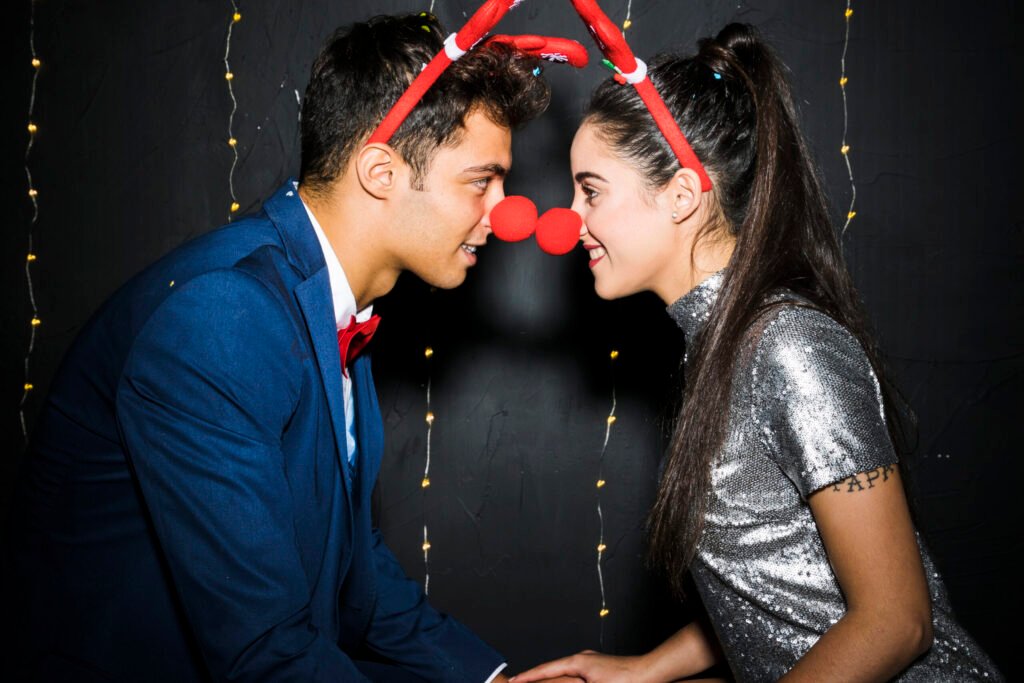 young couple with red deer antlers headbands funny noses